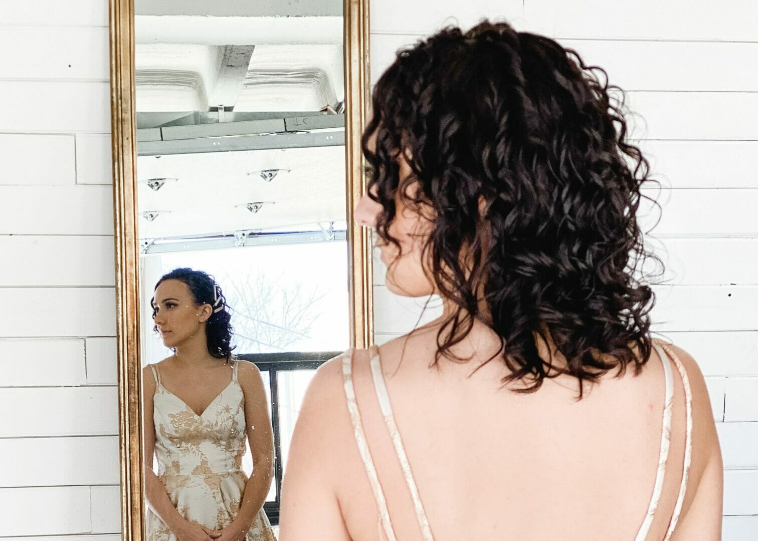 girl in mirror reflection with curled hair