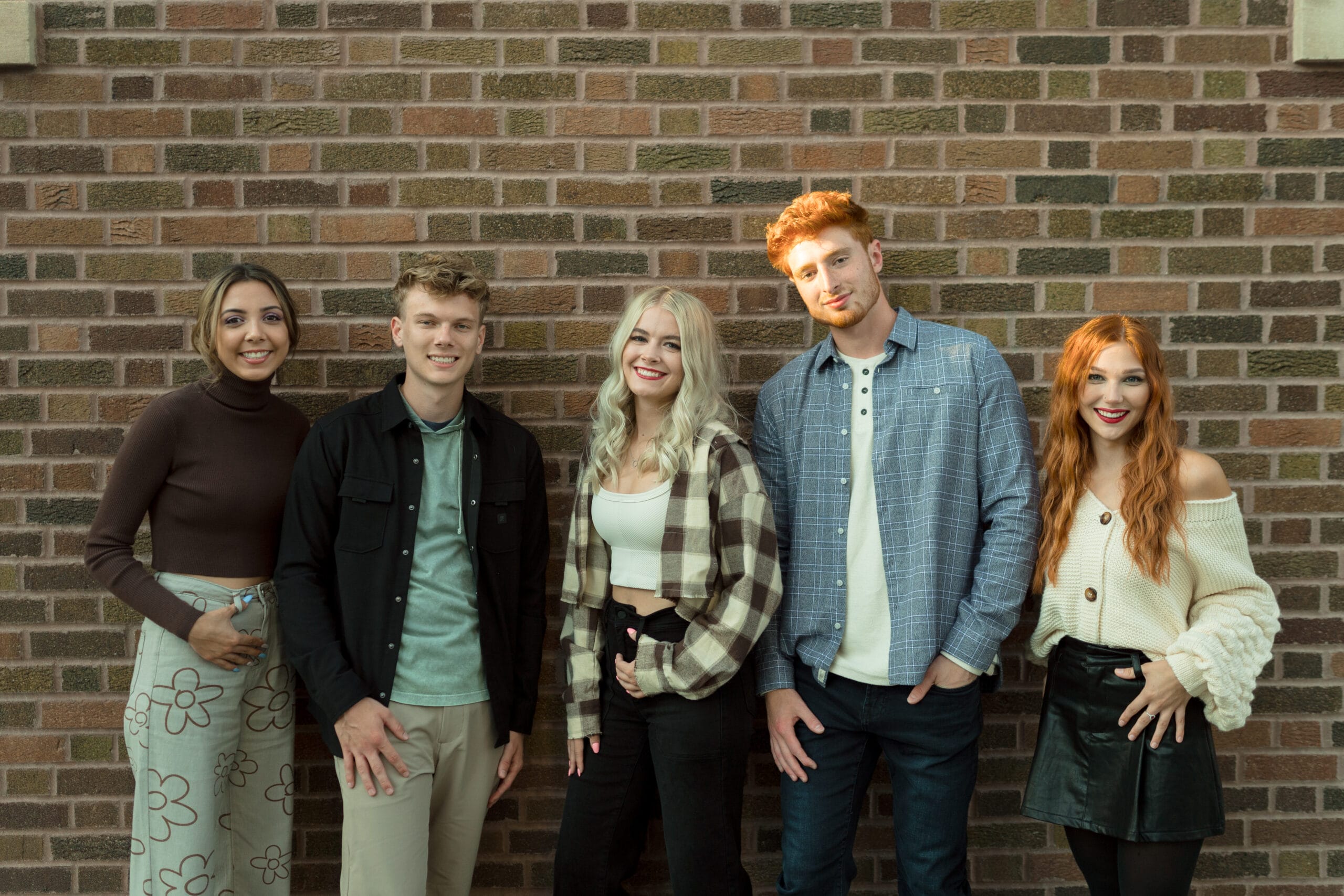people standing in front of brick wall