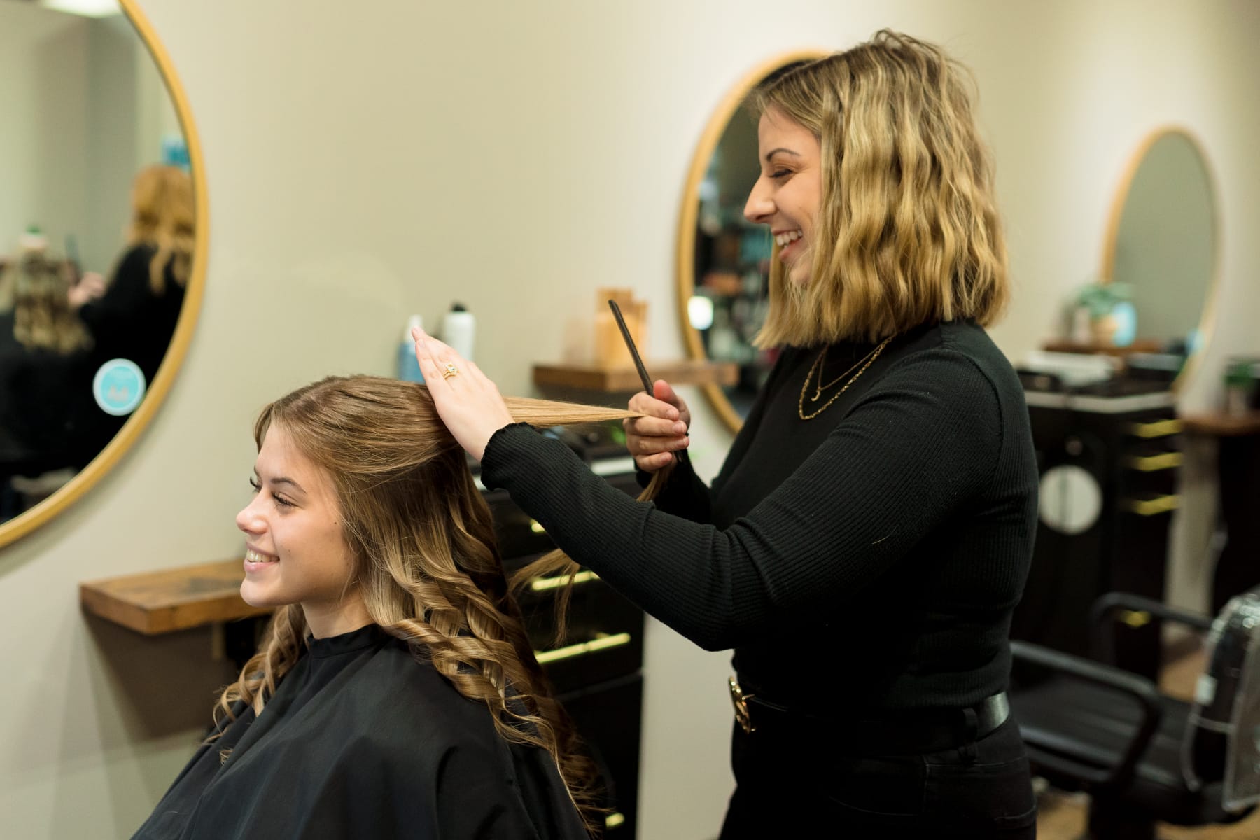 stylist smiling while curling hair
