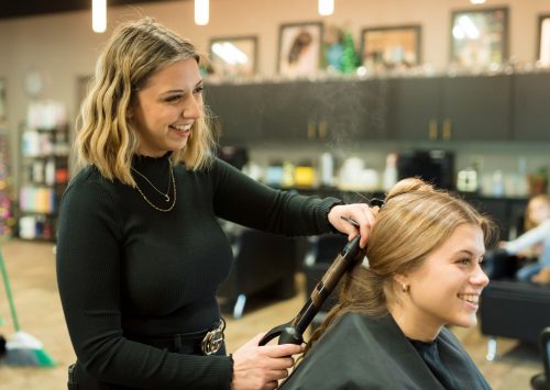 stylist curling clients' hair